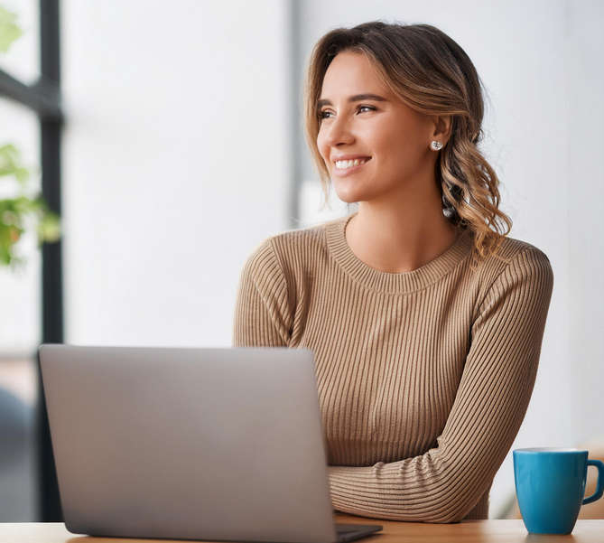 Female Advertising Manager with coffee in front of notebook